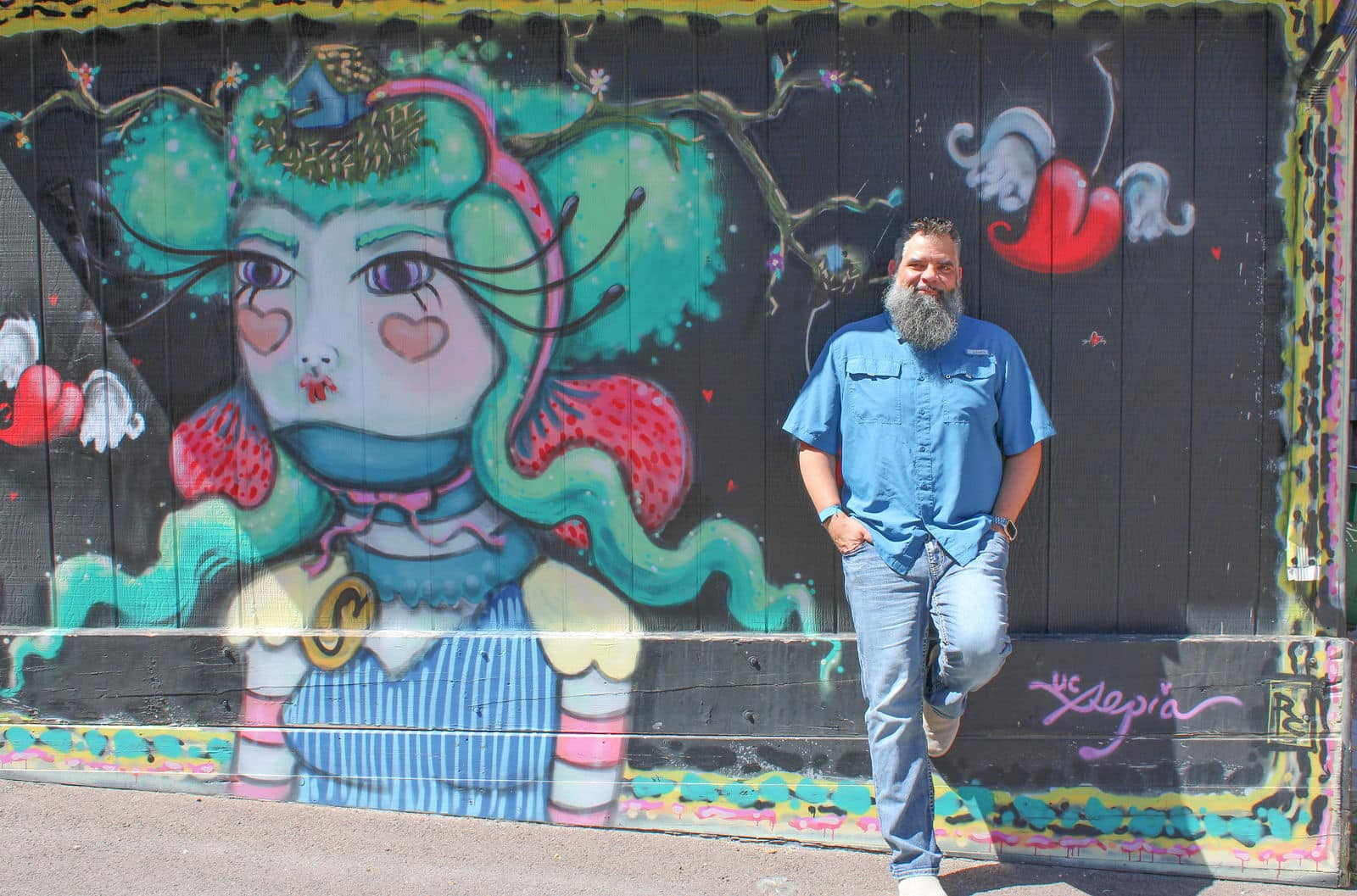 JP Fluellen standing in front of colorful mural